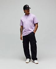 Lavender jersey Mens Oscar Oversized Tee with a white embroidered Psycho Bunny logo on the left chest, black relaxed cargo pants, and a black cap featuring the iconic white-red bunny skull. (3)