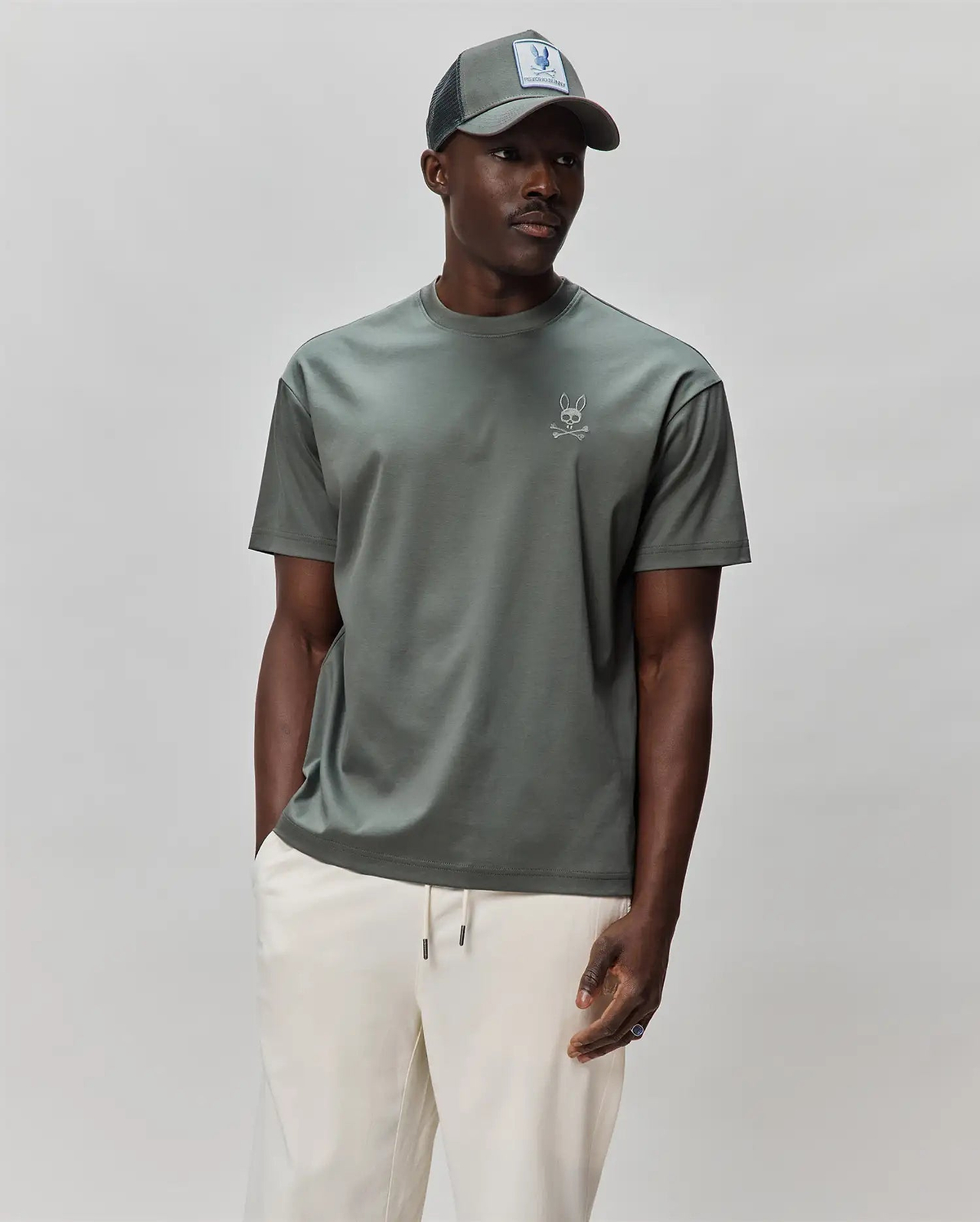 Mens Oscar Oversized Tee in olive green jersey knit, featuring a small, embroidered light grey Psycho Bunny skull logo on the left chest for a relaxed streetwear look.