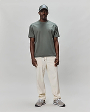 Mens Oscar Oversized Tee in muted sage green, crafted from soft jersey knit, featuring a small, embroidered white Psycho Bunny skull logo on the left chest for premium streetwear style.