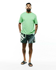 Mens Oscar Relaxed Fit Tee in light green jersey with a tonal embroidered bunny skull on the left chest, paired with dark green striped shorts featuring white, light green, and yellow accents and a small embroidered bunny skull on the leg.