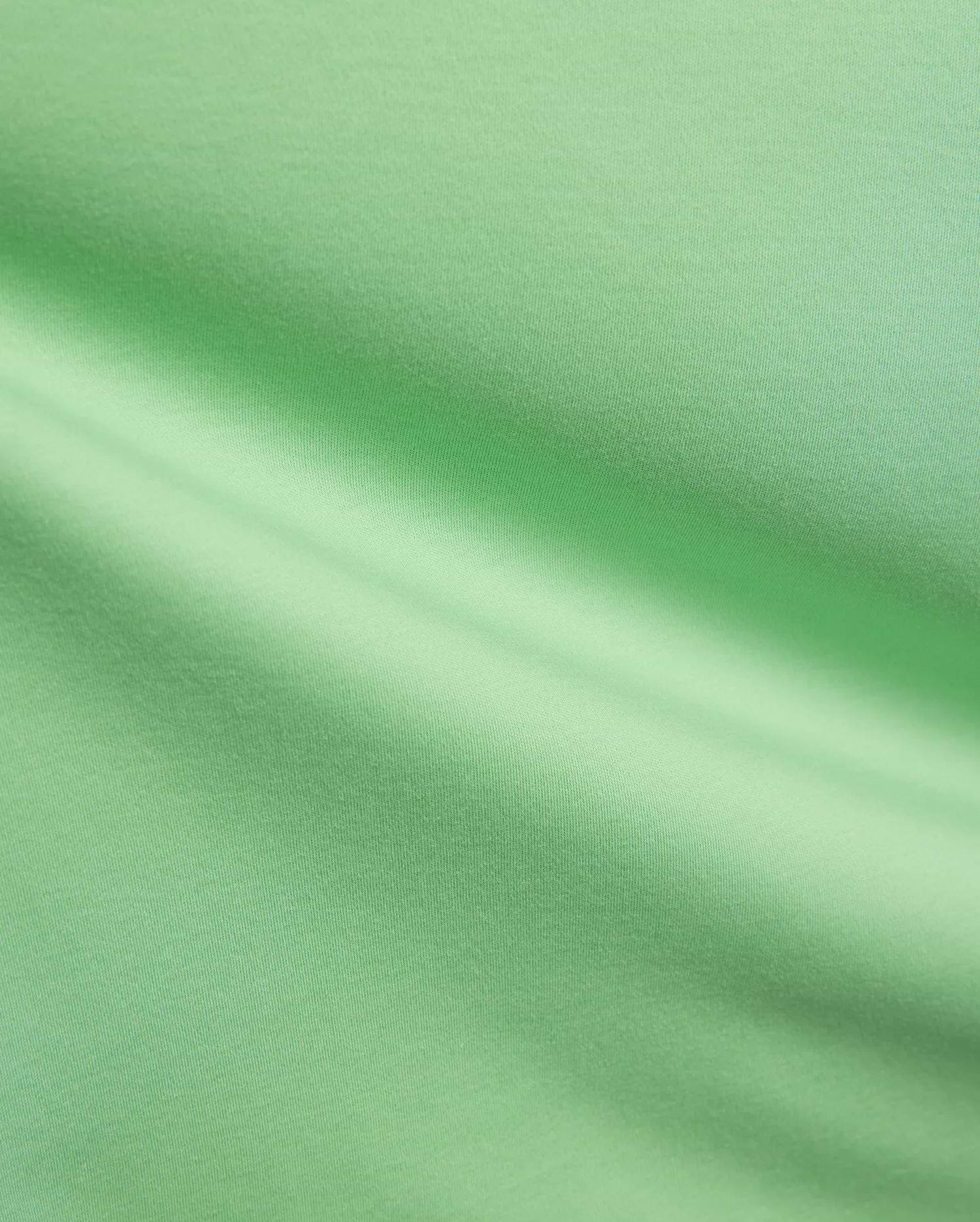 Mens Oscar Relaxed Fit Tee in a fresh, vibrant light green, premium soft jersey knit fabric, highlighting its smooth, breathable texture and elegant, relaxed drape with subtle folds and shadows.