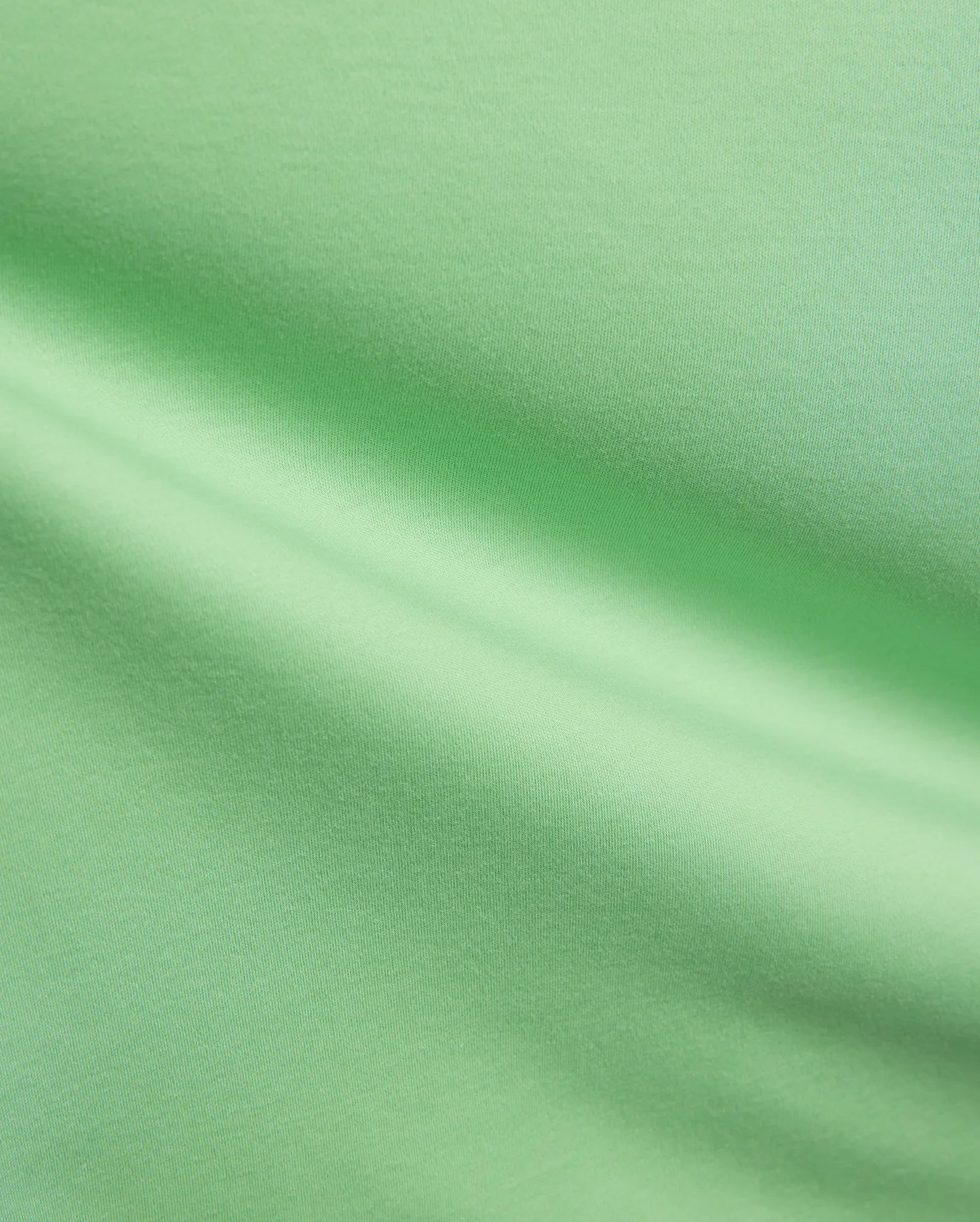 Mens Oscar Relaxed Fit Tee in a fresh, vibrant light green, premium soft jersey knit fabric, highlighting its smooth, breathable texture and elegant, relaxed drape with subtle folds and shadows.