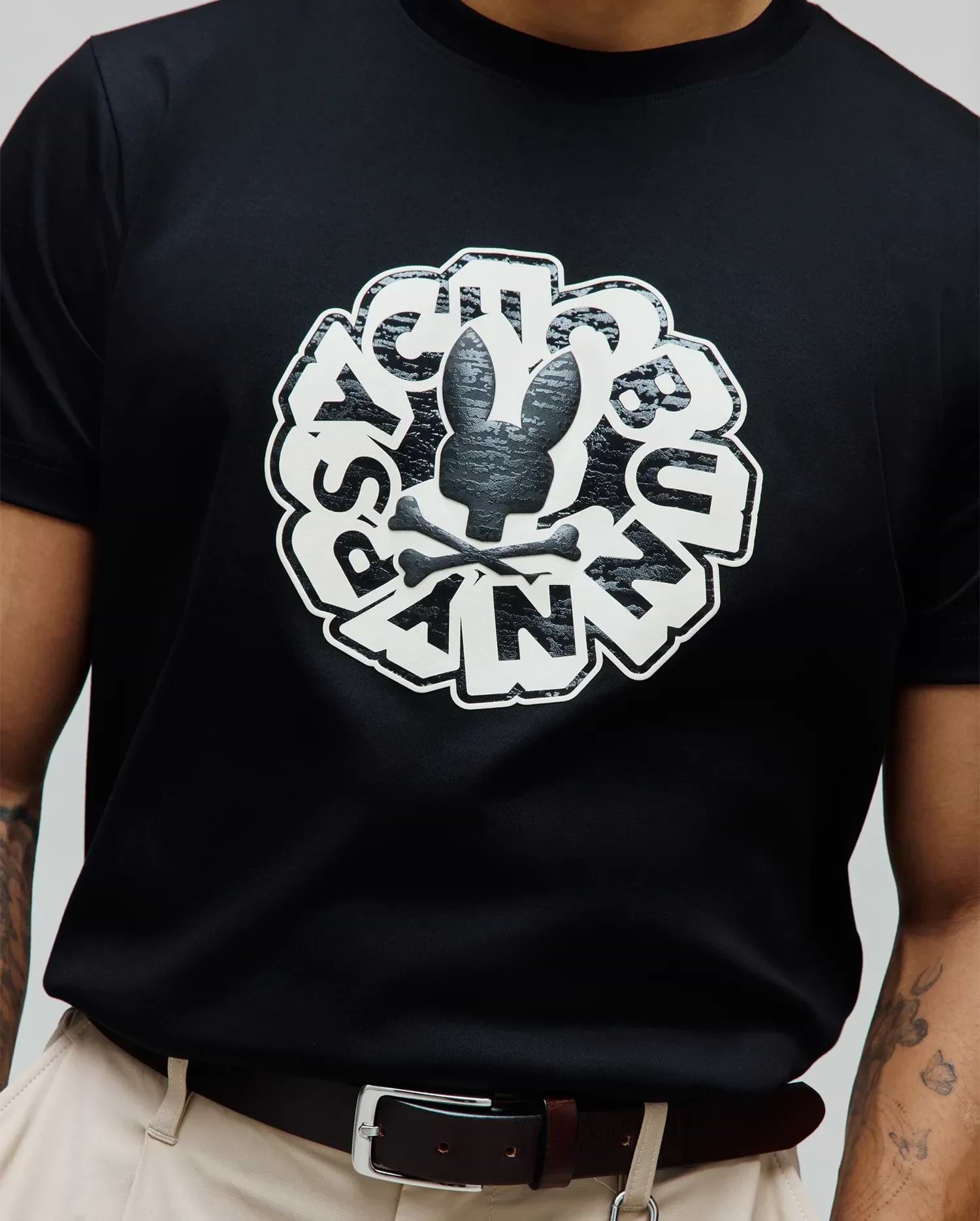 Mens Toby Graphic Tee, classic fit black jersey knit featuring a large central white and textured black Psycho Bunny skull and crossbones graphic, encircled by distressed PSYCHO BUNNY text.