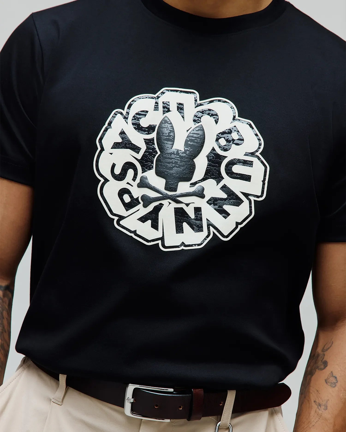 Mens Toby Graphic Tee, classic fit black jersey knit featuring a large central white and textured black Psycho Bunny skull and crossbones graphic, encircled by distressed PSYCHO BUNNY text.