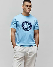 Mens Toby Graphic Tee, sky blue classic fit jersey t-shirt with a large central navy blue circular graphic featuring the iconic Psycho Bunny skull and text.