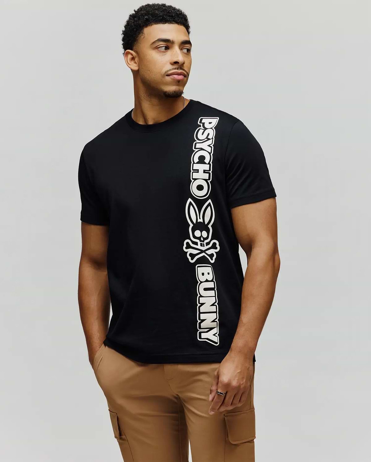 Mens Toby Wordmark Tee, black classic fit jersey knit t-shirt with a large vertical white Psycho Bunny wordmark and bunny skull graphic on the left side. (3)