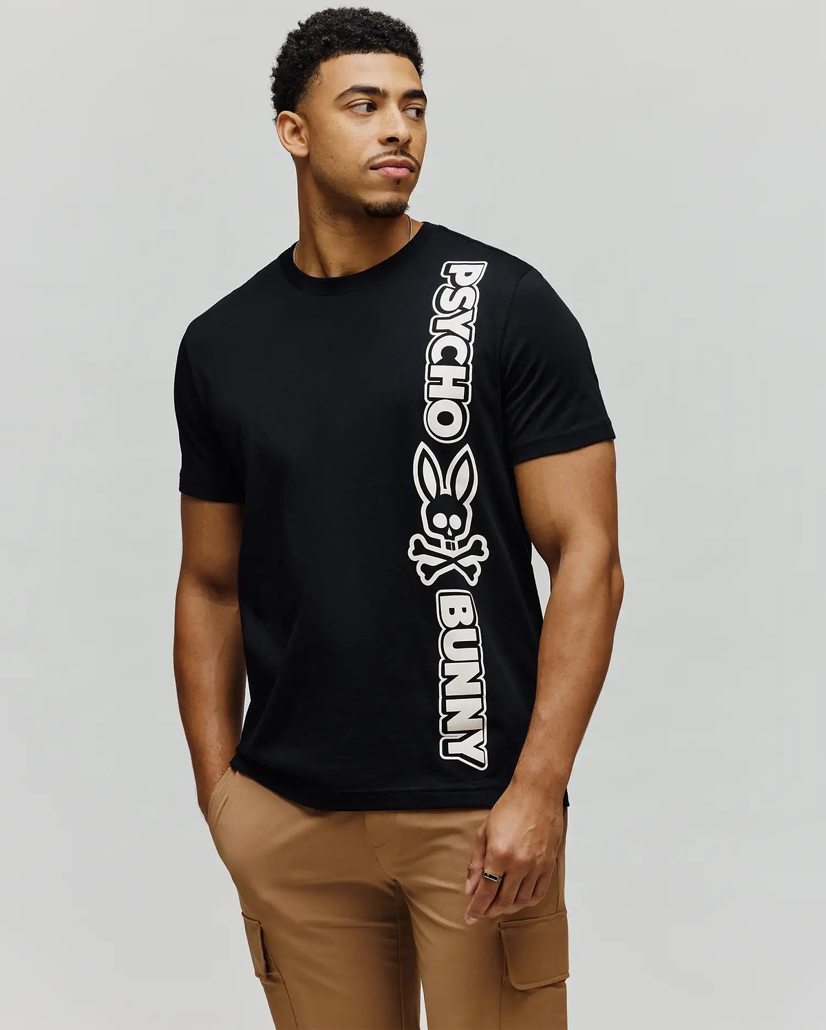 Mens Toby Wordmark Tee, black classic fit jersey knit t-shirt with a large vertical white Psycho Bunny wordmark and bunny skull graphic on the left side. (3)