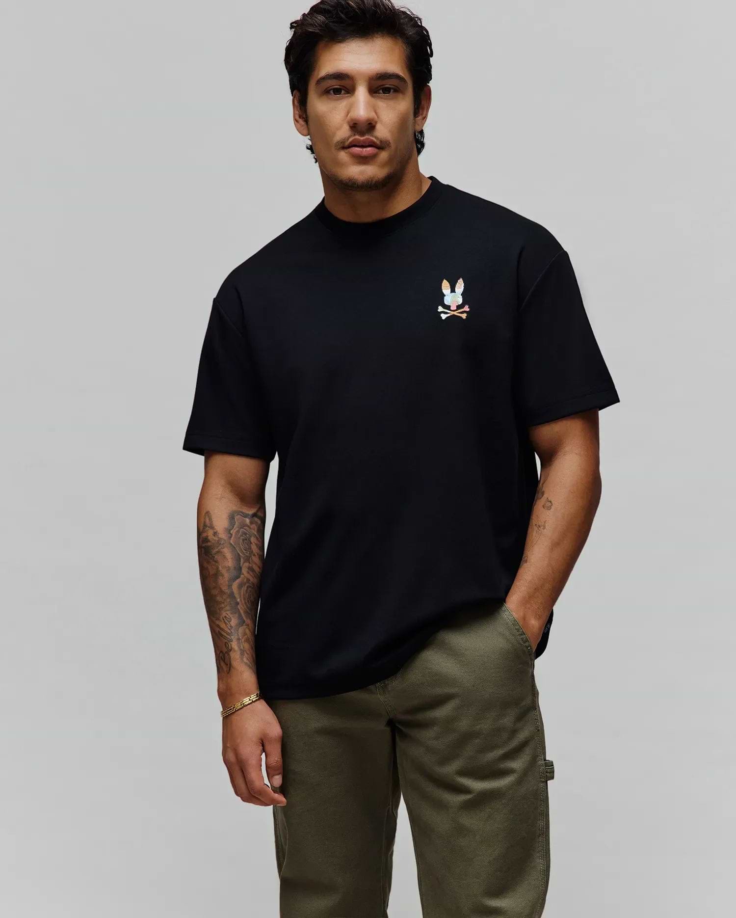 Mens Ara Oversized Tee in black jersey knit, featuring a relaxed fit and a small, vibrant multi-color embroidered Psycho Bunny skull logo on the left chest.