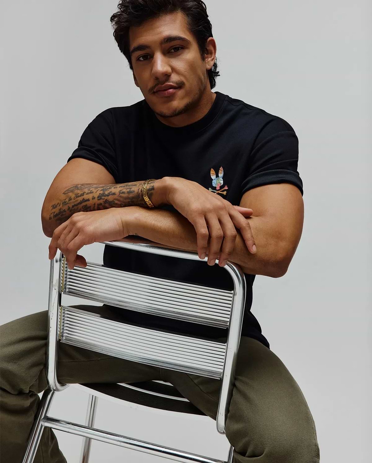 Black Mens Ara Oversized Tee in soft jersey, featuring a small, vibrant multi-color embroidered Psycho Bunny skull logo on the left chest for a relaxed fit.