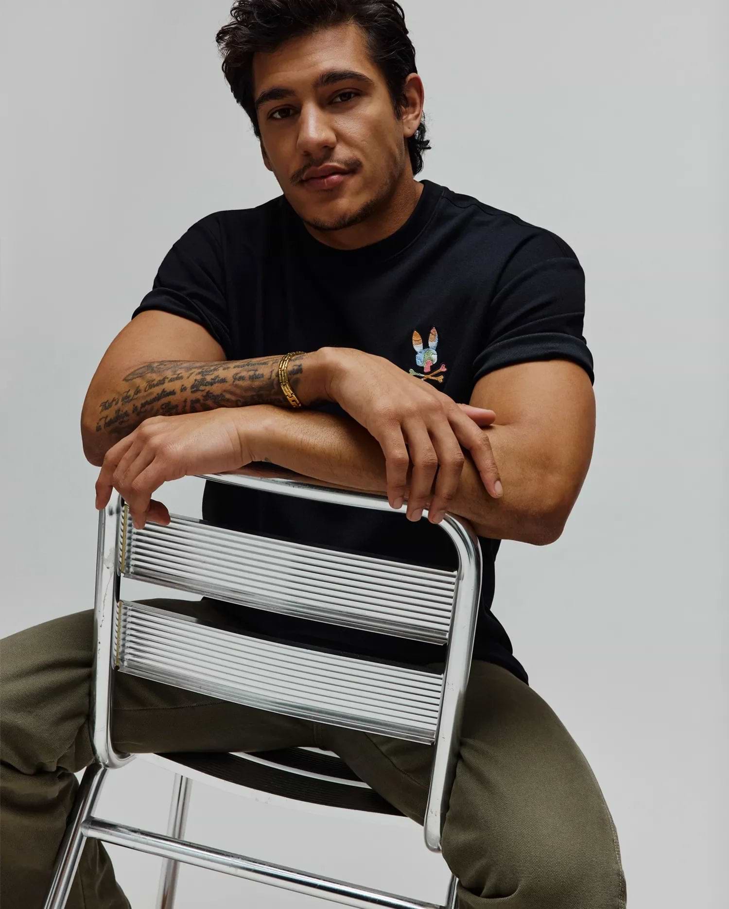 Black Mens Ara Oversized Tee in soft jersey, featuring a small, vibrant multi-color embroidered Psycho Bunny skull logo on the left chest for a relaxed fit.