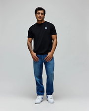 Black Mens Aiden Back Graphic Tee in classic fit jersey with a small light blue embroidered Psycho Bunny skull logo on the left chest, paired with relaxed fit medium wash blue denim jeans. (4)