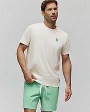 MENS AIDEN BACK GRAPHIC TEE in cream, crafted from soft jersey knit cotton with a classic fit. Features a small, vibrant green embroidered Psycho Bunny skull logo on the left chest and an implied back graphic. (3)