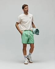 Cream Mens Aiden Back Graphic Tee, a classic fit jersey tee with a small green embroidered Psycho Bunny skull logo on the left chest, styled with relaxed mint green drawstring shorts. (4)