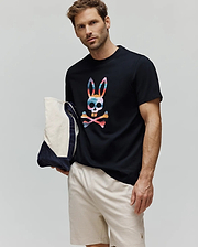 Mens Raphael Graphic Tee, a black classic-fit jersey t-shirt with a large multicolor bunny skull graphic on the chest, paired with light beige relaxed-fit pique shorts featuring a small embroidered bunny logo. (2)