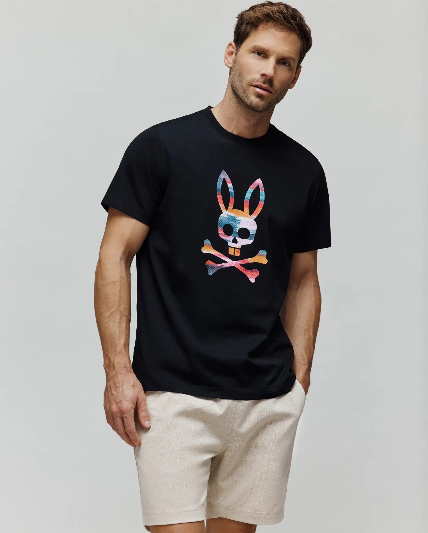 Mens Raphael Graphic Tee, black classic fit jersey t-shirt featuring a large, vibrant multi-color striped Psycho Bunny skull and crossbones graphic on the center chest. (4)