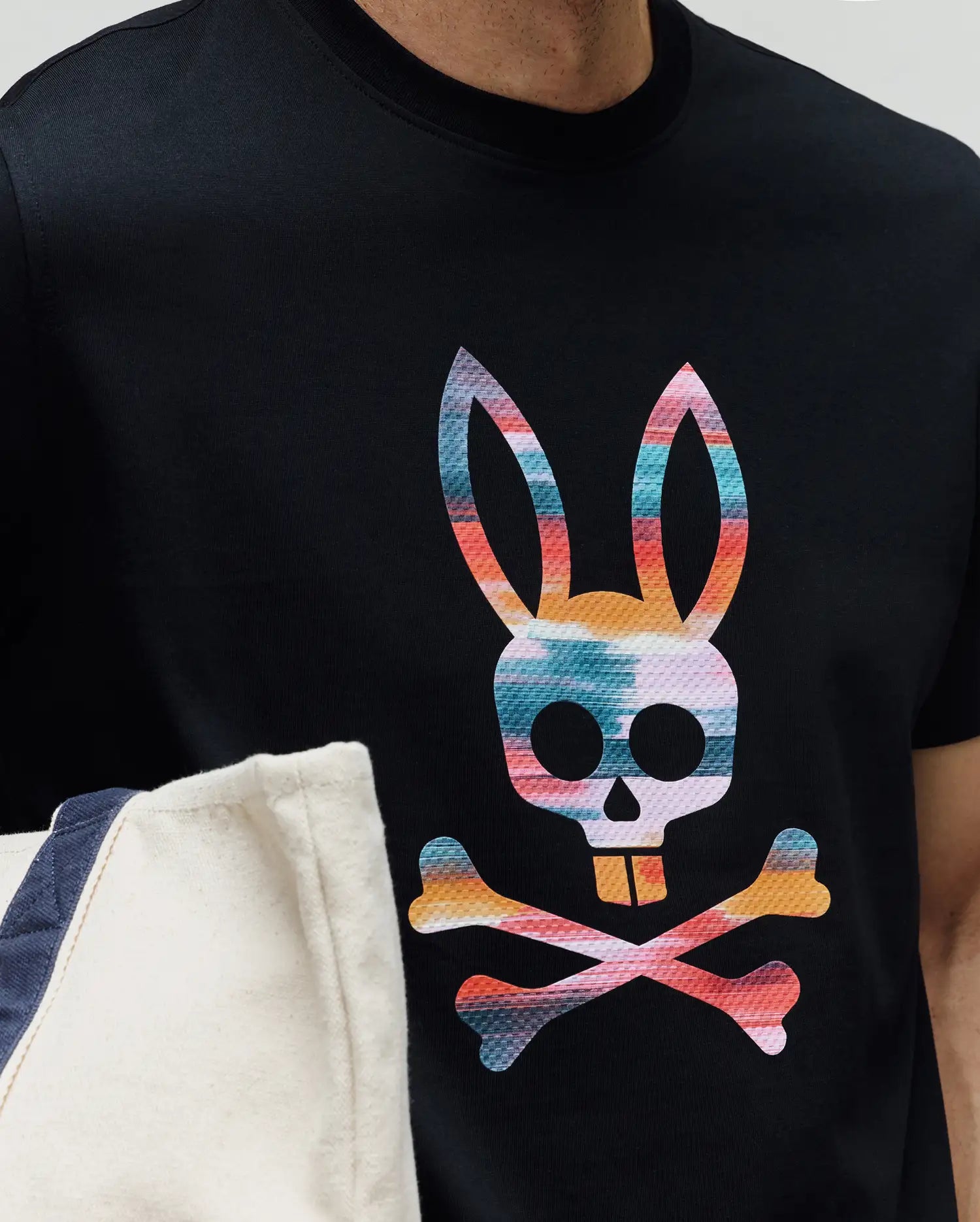 Mens Raphael Graphic Tee, a classic fit black jersey knit t-shirt featuring a large, vibrant, multi-color Psycho Bunny skull and crossbones graphic print on the chest. (3)