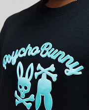 Mens Aram Graphic Tee, black jersey knit with a classic fit, featuring a large central light blue raised graphic of the Psycho Bunny script and iconic bunny skull logo with crossbones. (3)