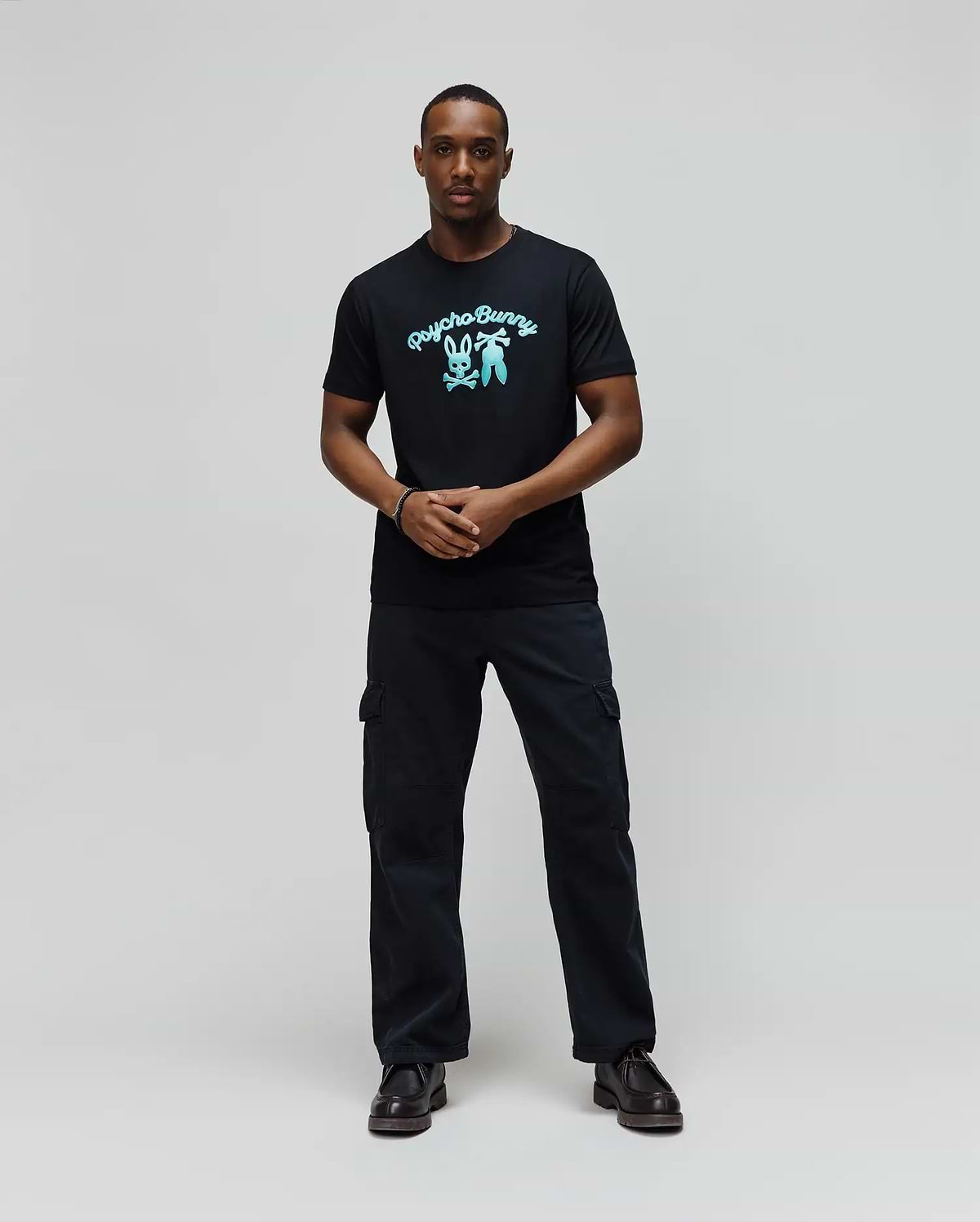 Mens Aram Graphic Tee, a classic fit black soft jersey t-shirt featuring a large, vibrant light blue Psycho Bunny script logo and iconic bunny skull graphic on the chest. (4)