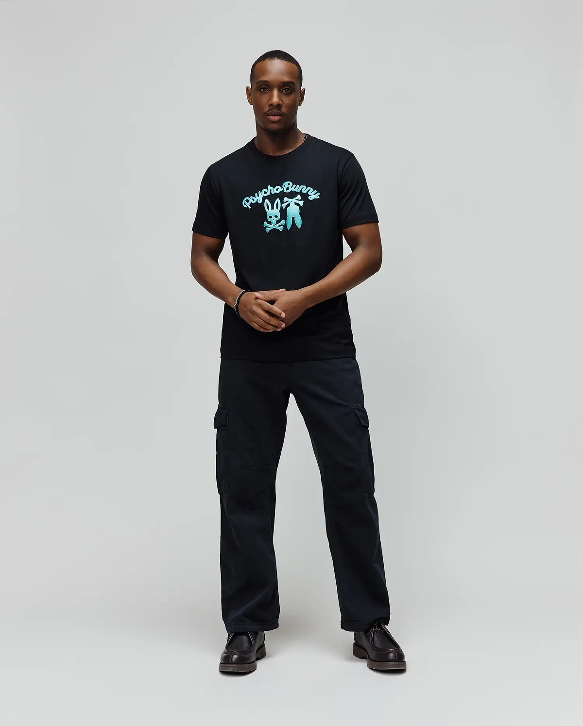 Mens Aram Graphic Tee, a classic fit black soft jersey t-shirt featuring a large, vibrant light blue Psycho Bunny script logo and iconic bunny skull graphic on the chest. (4)