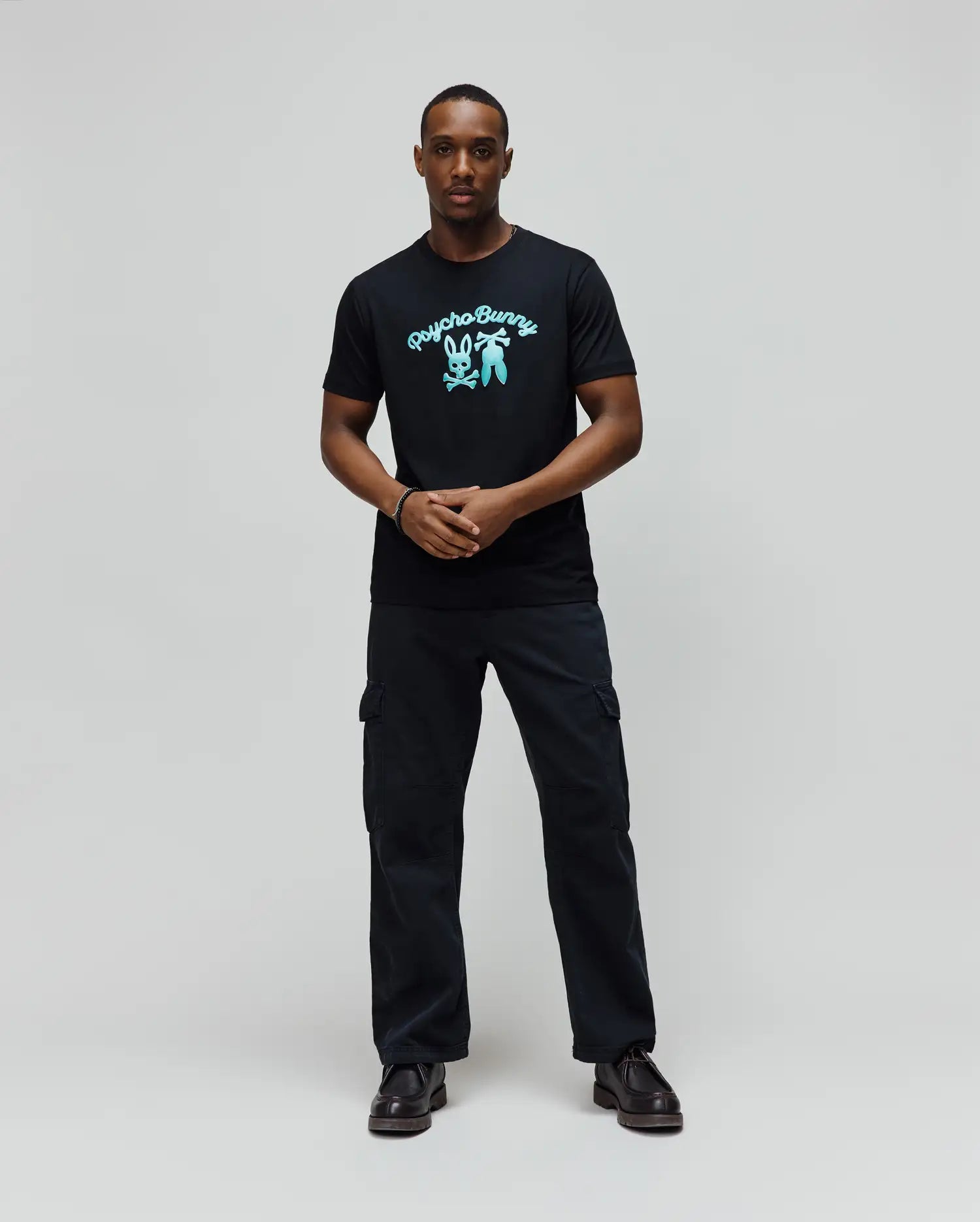 Mens Aram Graphic Tee, a classic fit black soft jersey t-shirt featuring a large, vibrant light blue Psycho Bunny script logo and iconic bunny skull graphic on the chest. (4)
