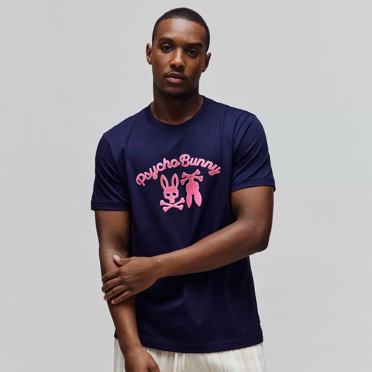 Mens Aram Graphic Tee, a navy blue classic fit smooth jersey knit t-shirt featuring a large hot pink Psycho Bunny script and bunny skull logo graphic on the chest. (2)