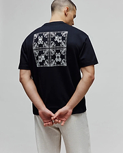 Black Mens Luke Back Graphic Tee in soft jersey, classic fit, featuring a large white bandana-style graphic on the back with four Psycho Bunny skull logos and paisley patterns.