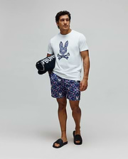 White Mens Luke Graphic Tee, classic fit, with a large ornate blue and purple Psycho Bunny skull chest graphic. Navy patterned swim shorts feature an all-over floral and small bunny skull design. (4)