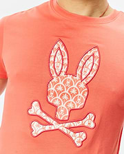 Mens Brad Graphic Tee, coral classic fit jersey t-shirt featuring a large central Psycho Bunny skull logo graphic, filled with a white palm tree and mini bunny skull pattern, outlined in red.