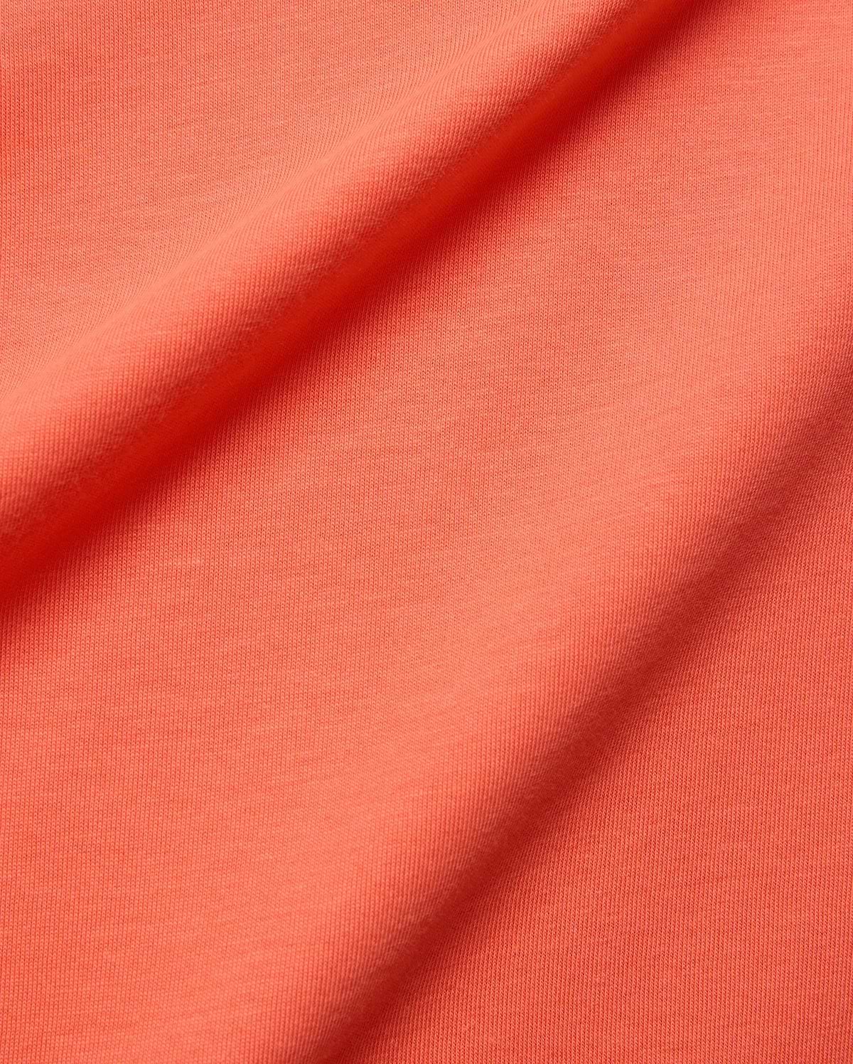 Mens Brad Graphic Tee fabric swatch in a rich, vibrant coral hue, showcasing a soft, finely textured jersey knit, embodying Psycho Bunny's premium menswear and bold color aesthetic.