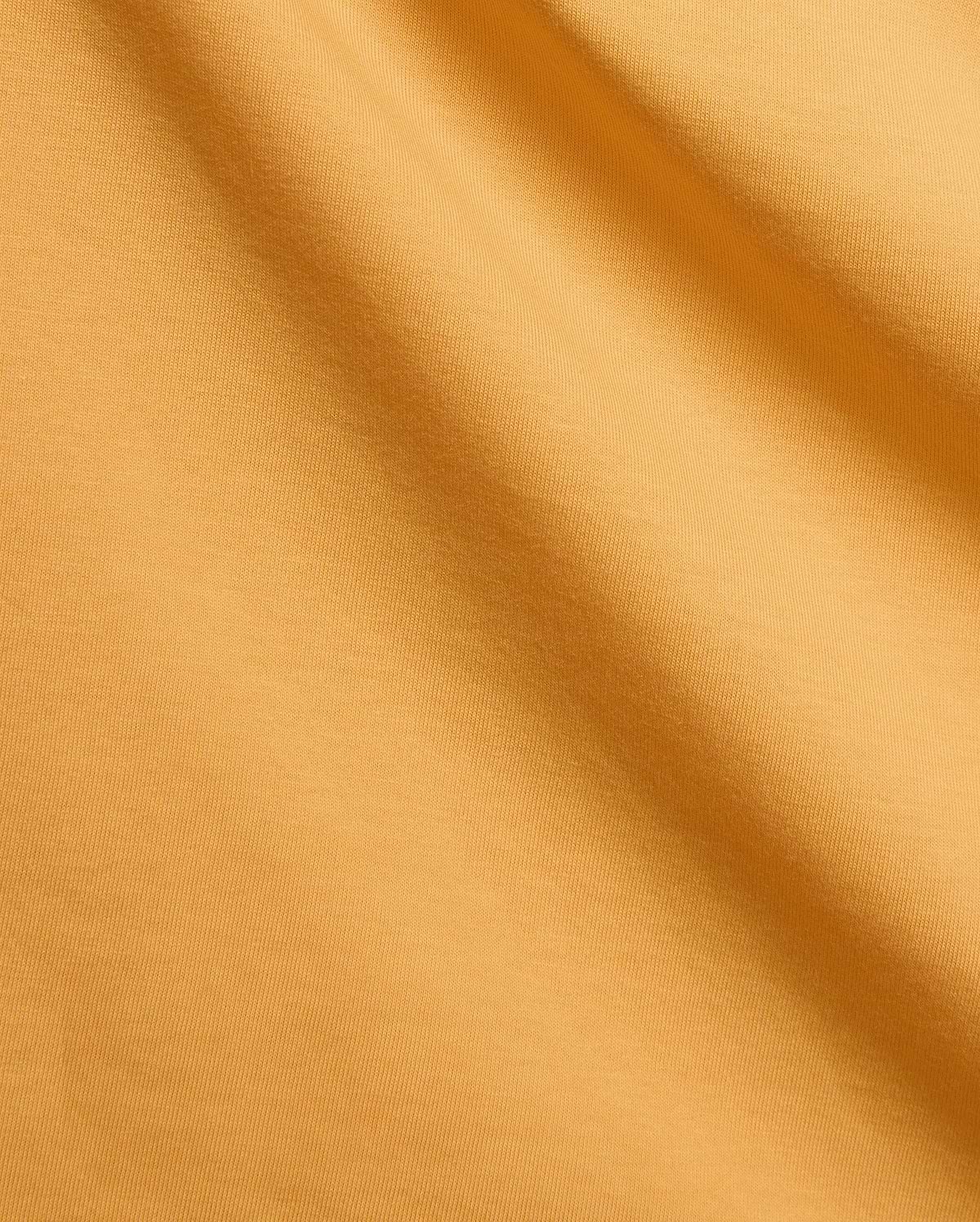 Mens Brad Graphic Tee in vibrant marigold jersey knit fabric with subtle folds, a premium Psycho Bunny streetwear piece featuring an iconic bunny skull logo graphic.