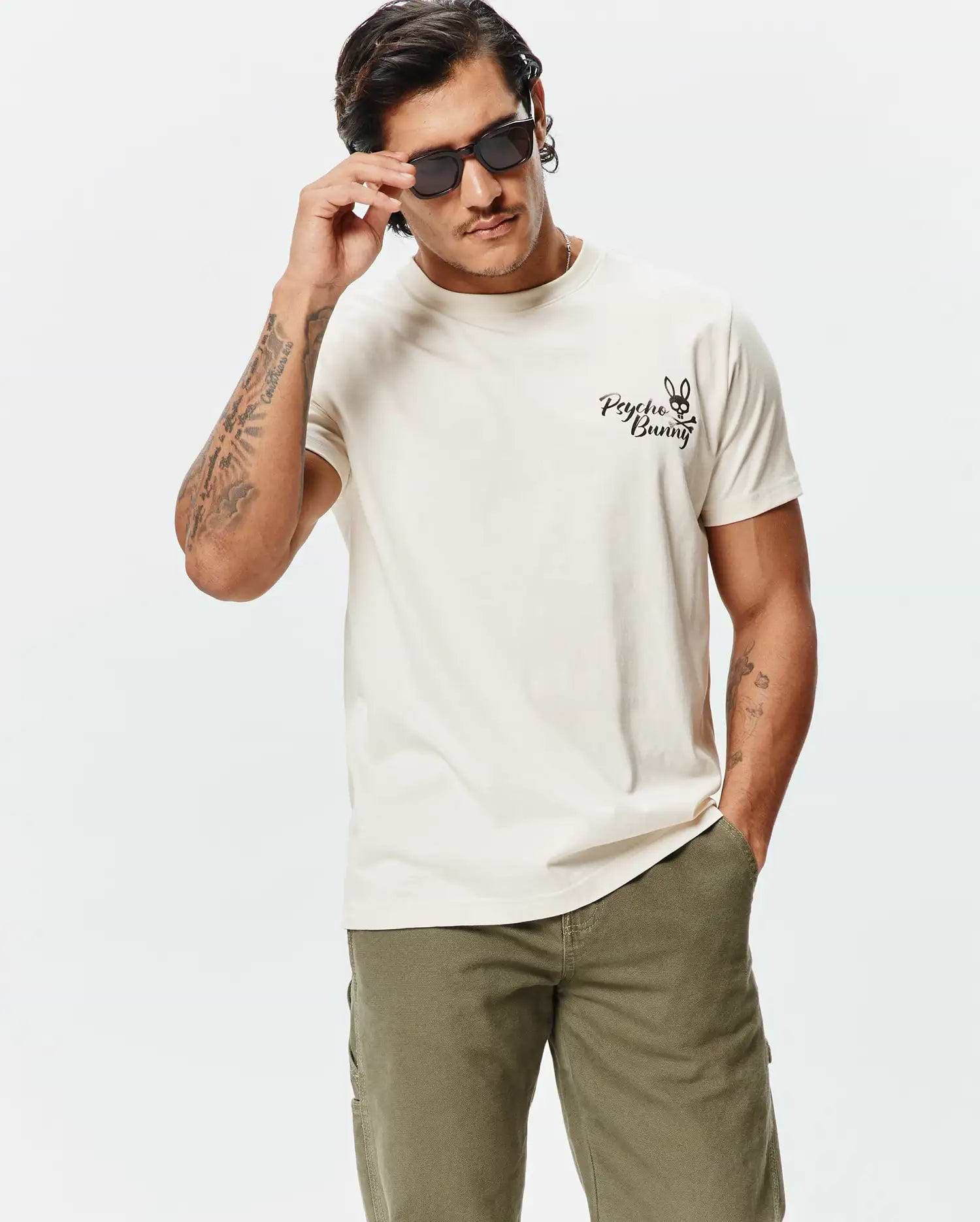 Mens Colin Back Graphic Tee, a premium soft cream jersey t-shirt with a classic fit, featuring a small embroidered black Psycho Bunny skull logo on the left chest.