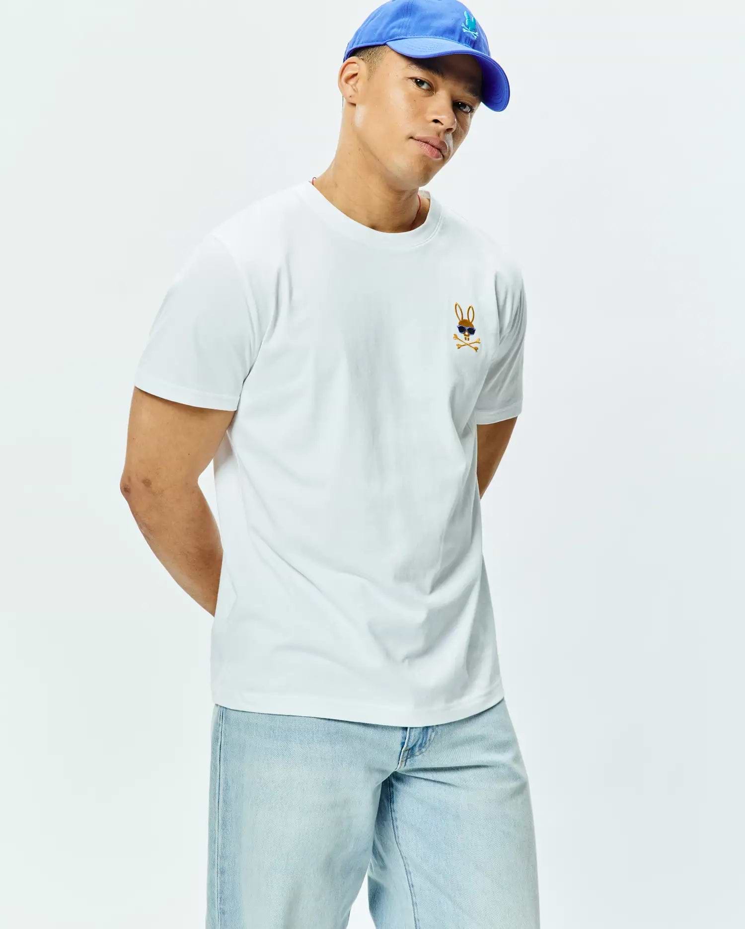 Mens Sunny Chest Graphic Tee, a classic fit white jersey t-shirt featuring a small embroidered brown Psycho Bunny skull logo with blue sunglasses and crossbones on the left chest.