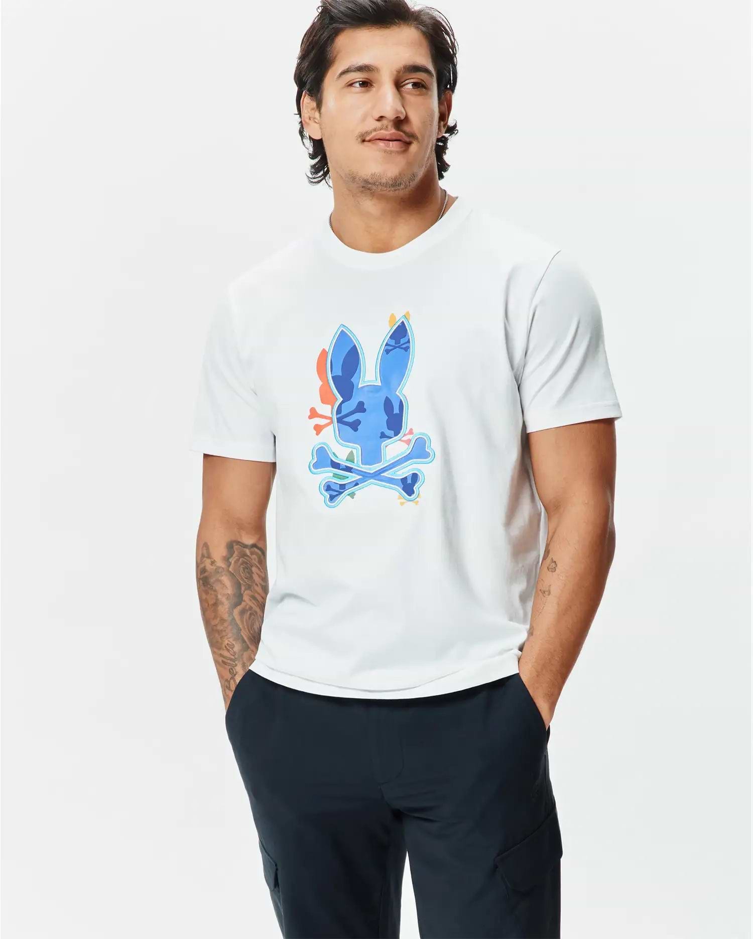 Mens Tanner Bunny Graphic Tee, a classic fit white jersey t-shirt featuring a large, vibrant blue, orange, and green camouflage-patterned Psycho Bunny skull logo graphic on the chest. (2)