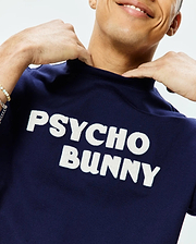 Mens Craig Wordmark Tee, a navy blue classic fit jersey t-shirt with a large, white felt Psycho Bunny wordmark prominently displayed across the chest. (2)