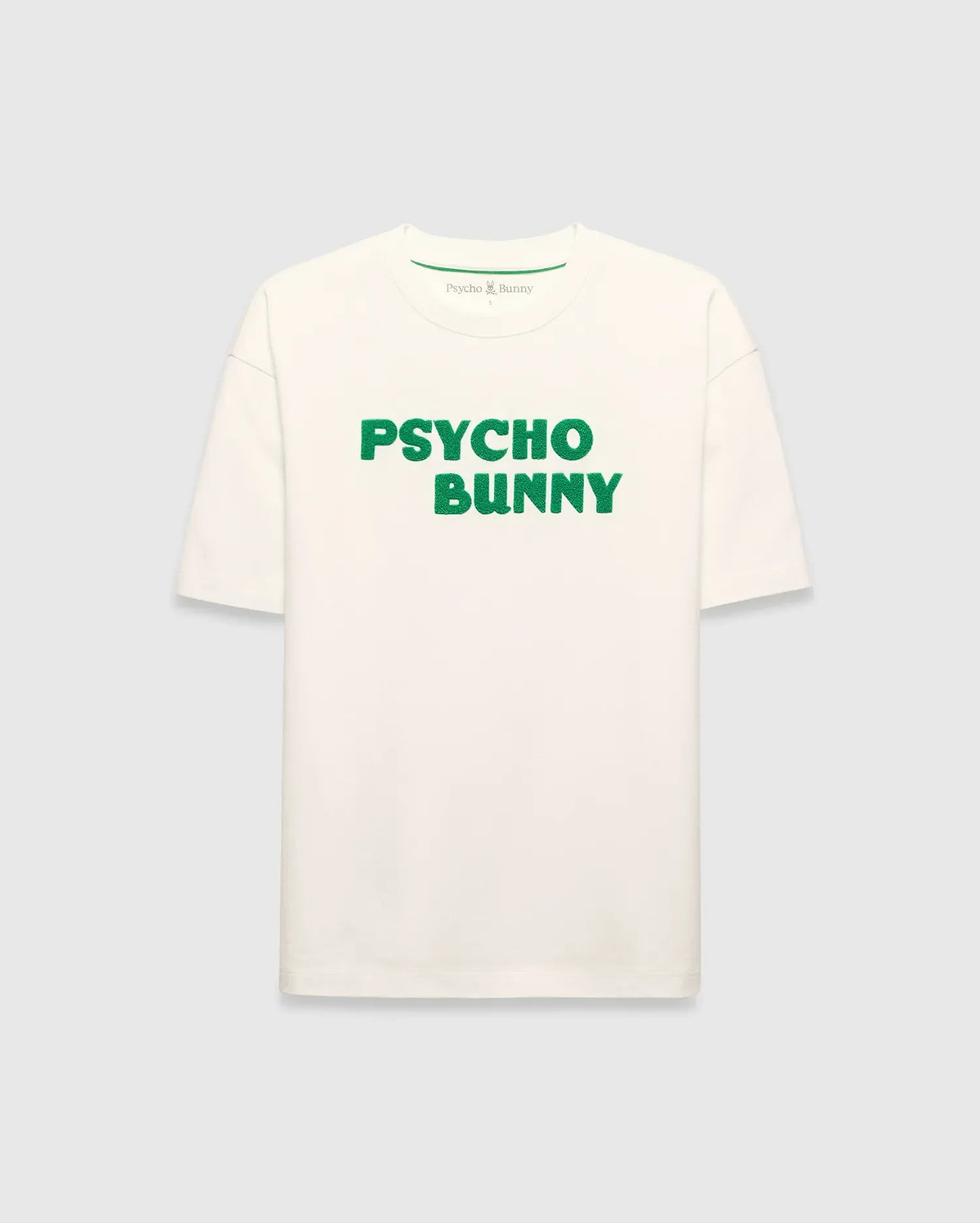 Mens Craig Wordmark Tee, a cream relaxed fit jersey t-shirt featuring a prominent green textured PSYCHO BUNNY wordmark graphic on the chest and a small green logo on the inner neck.