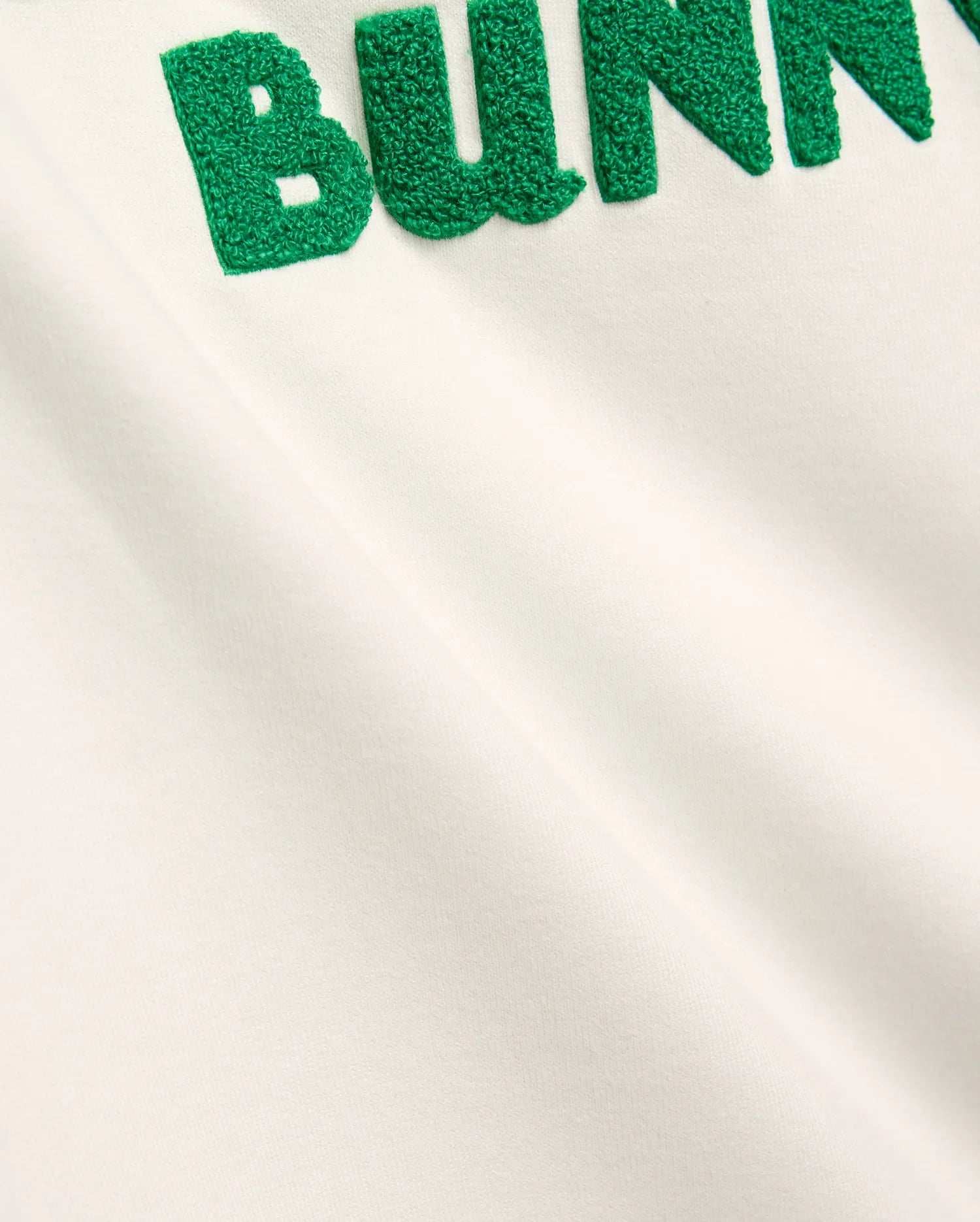Mens Craig Wordmark Tee in soft off-white jersey, showcasing a bold, large green textured chenille BUNNY wordmark prominently embroidered on the chest, embodying refined streetwear.