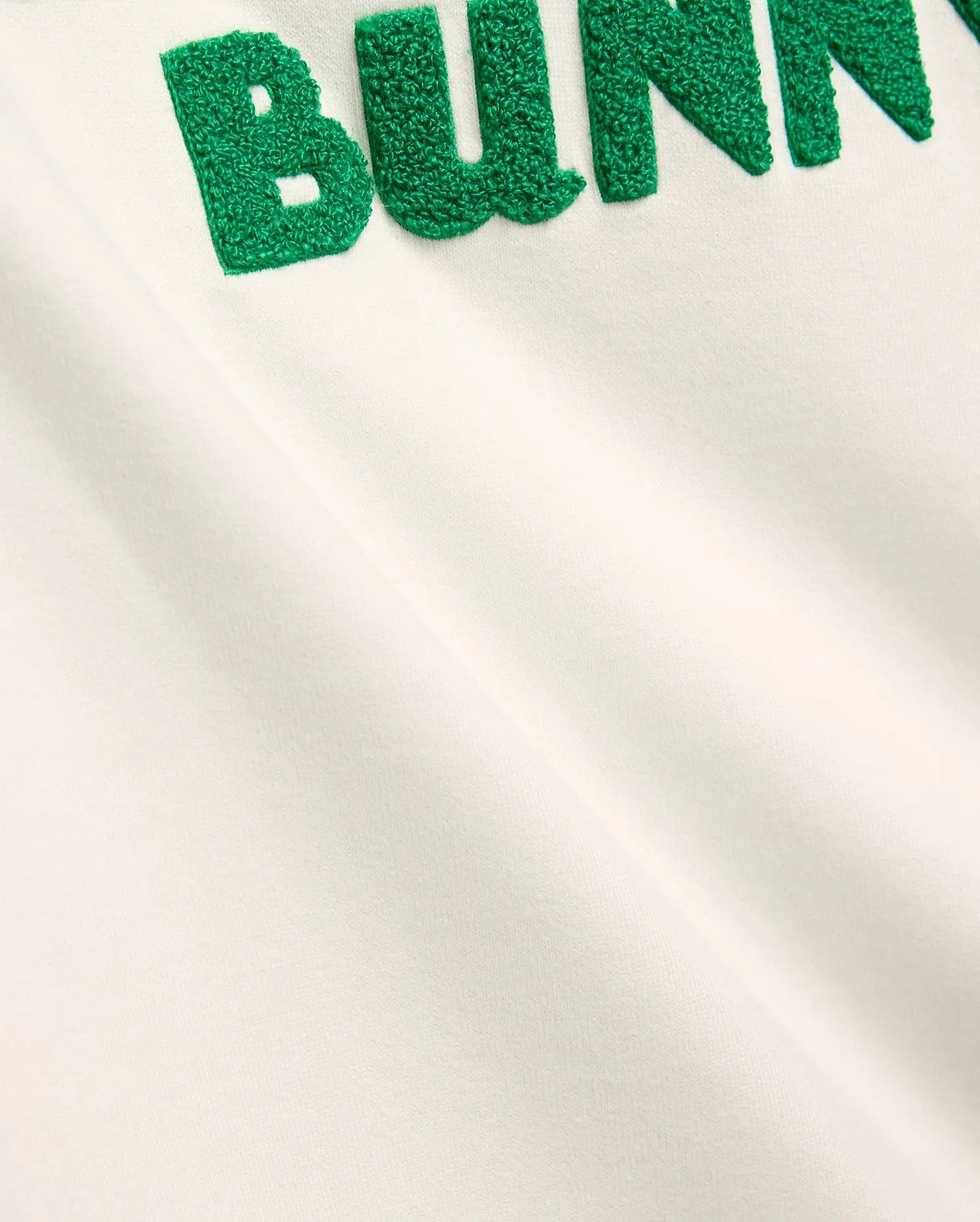 Mens Craig Wordmark Tee in soft off-white jersey, showcasing a bold, large green textured chenille BUNNY wordmark prominently embroidered on the chest, embodying refined streetwear.