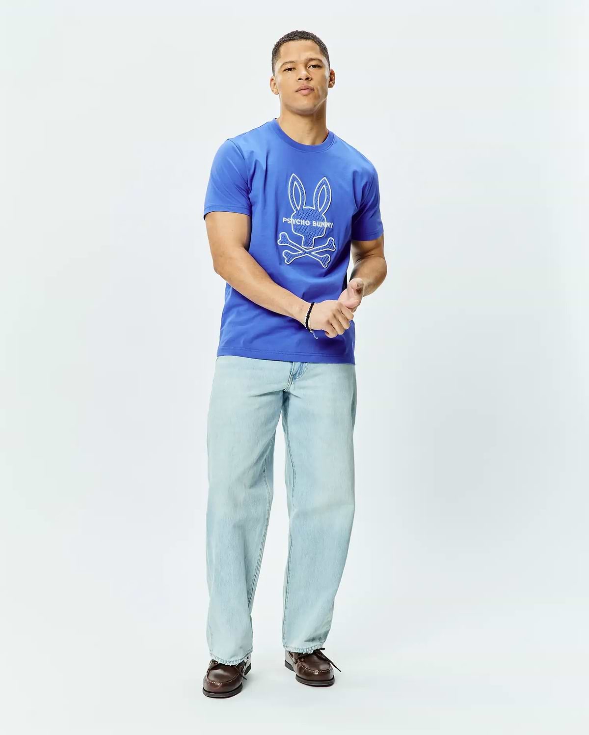 Mens Craig Graphic Tee, a royal blue classic fit jersey t-shirt featuring a large white Psycho Bunny skull and crossbones graphic logo centered on the chest. (4)