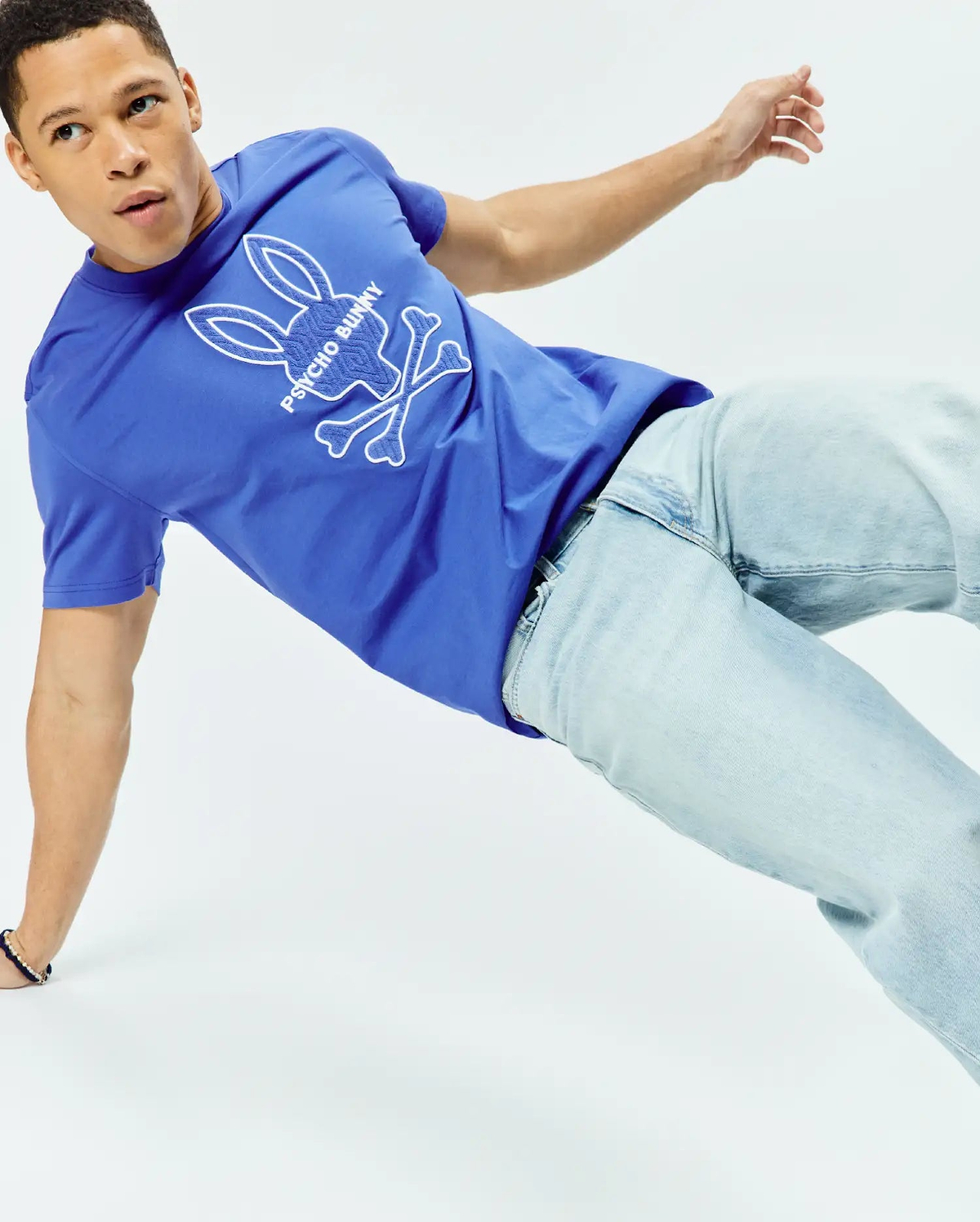 Mens Craig Graphic Tee, vibrant royal blue classic fit jersey t-shirt with a large white outline Psycho Bunny skull and crossbones logo featuring textured fill on the chest. (3)