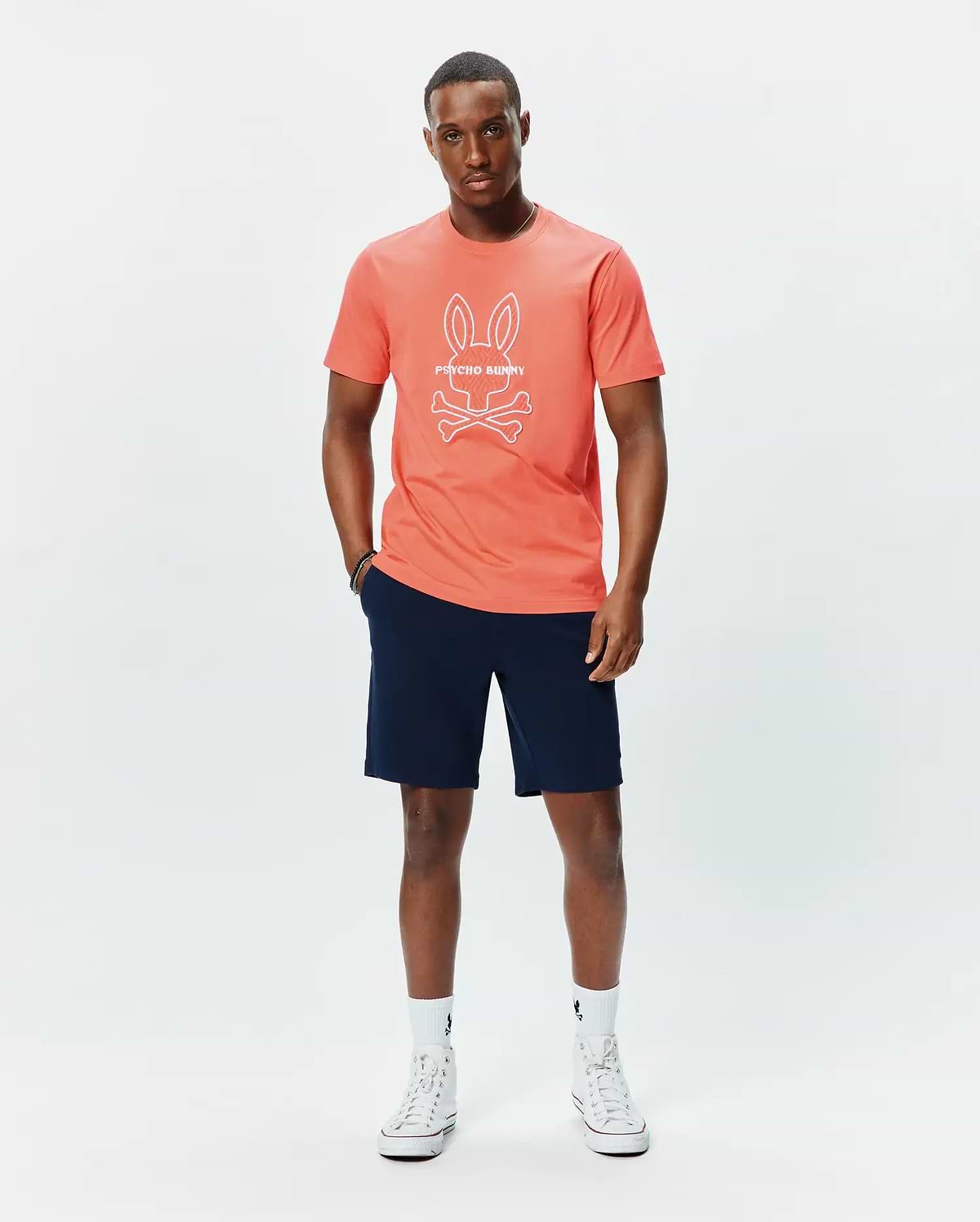 Mens Craig Graphic Tee in coral, featuring a classic fit and soft jersey fabric, with a large white Psycho Bunny skull and crossbones logo and text prominently displayed on the center chest. (4)