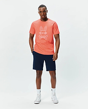Mens Craig Graphic Tee in coral, featuring a classic fit and soft jersey fabric, with a large white Psycho Bunny skull and crossbones logo and text prominently displayed on the center chest. (4)