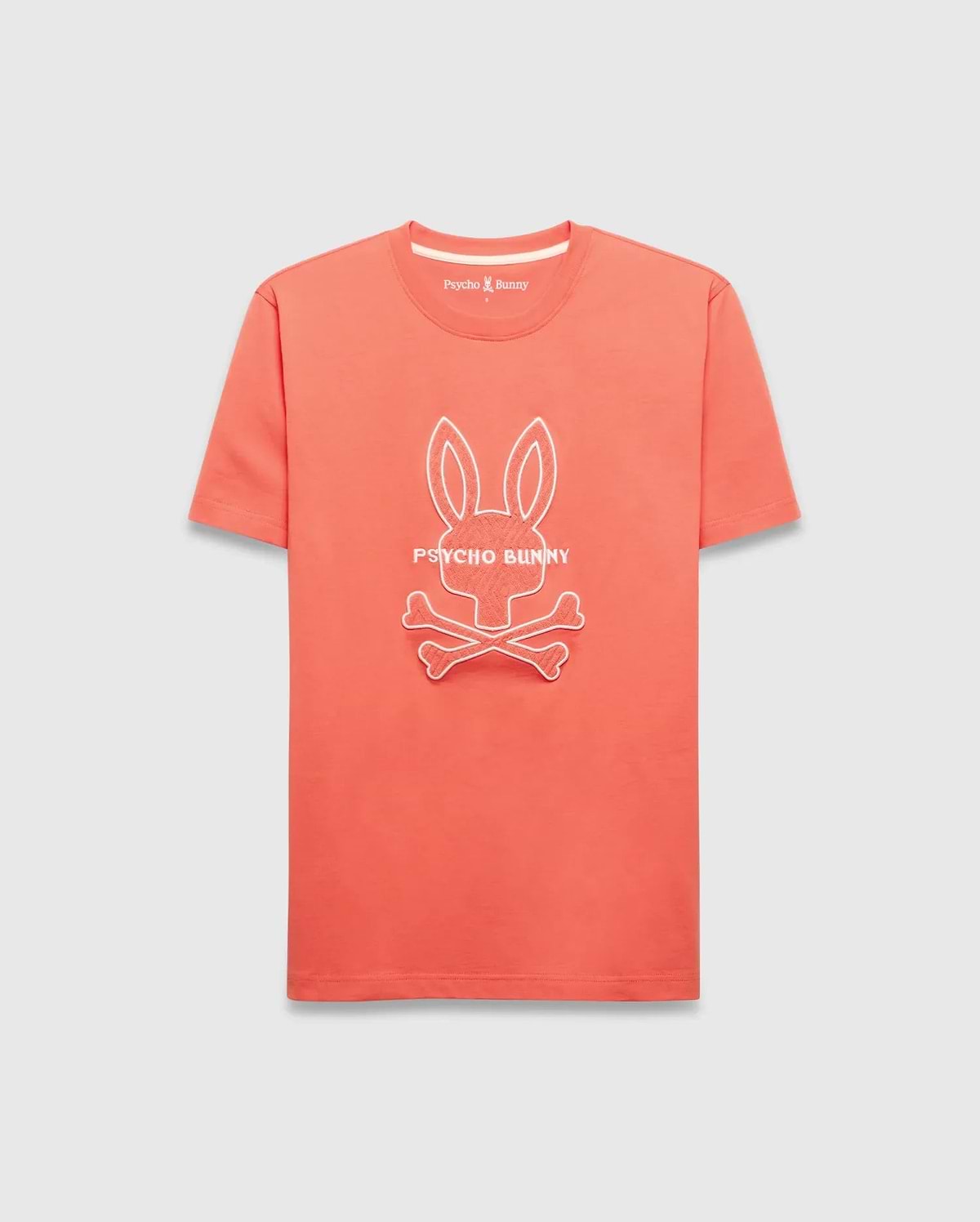 Mens Craig Graphic Tee in vibrant coral jersey, featuring a classic fit, white ribbed crew neck, and a large white outline Psycho Bunny skull graphic on the chest with a small embroidered logo. (1)