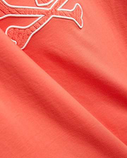 Mens Craig Graphic Tee in coral, made from soft jersey knit, featuring a large embroidered Psycho Bunny skull logo with a white outline and textured coral fill. (2)