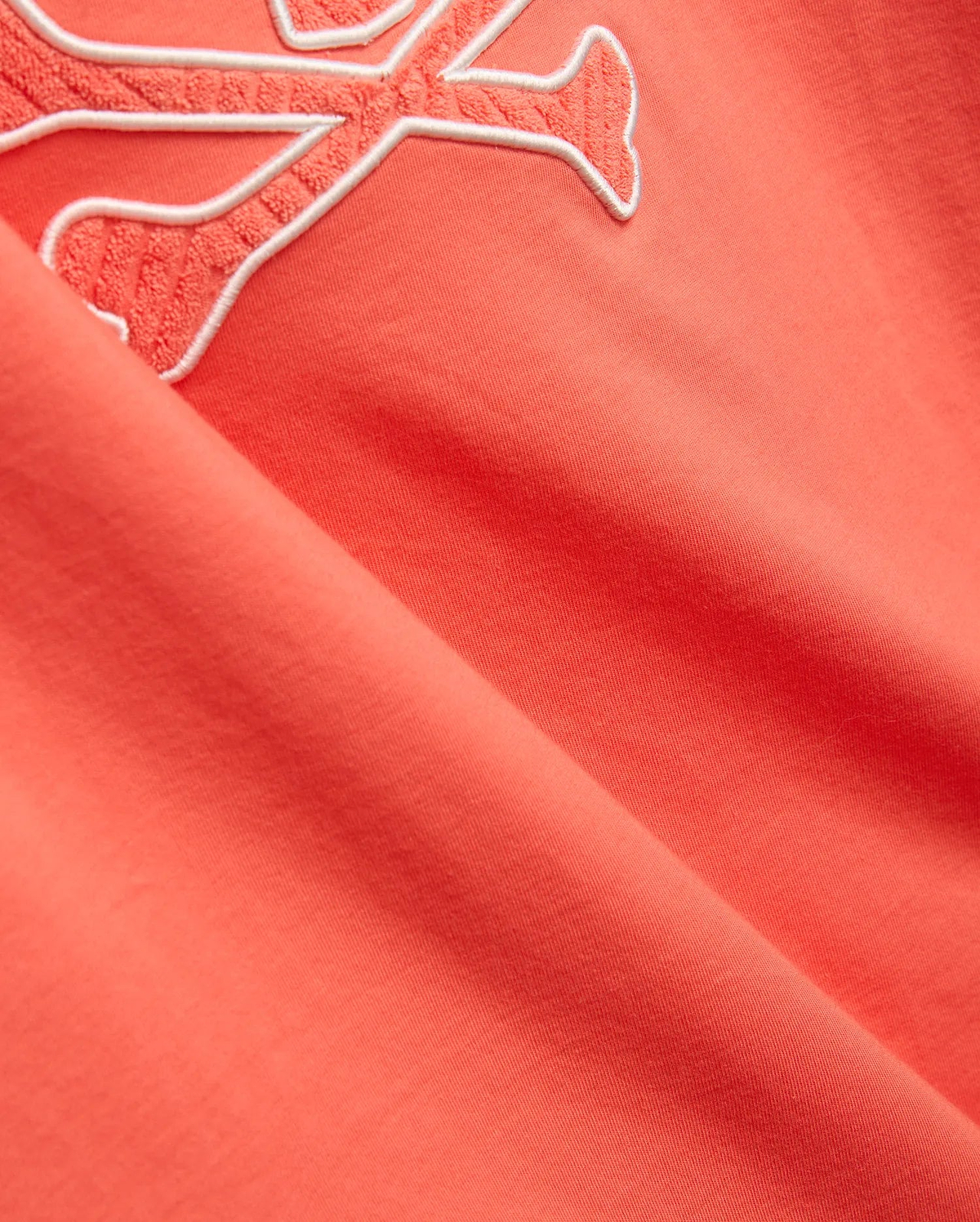 Mens Craig Graphic Tee in coral, made from soft jersey knit, featuring a large embroidered Psycho Bunny skull logo with a white outline and textured coral fill. (2)