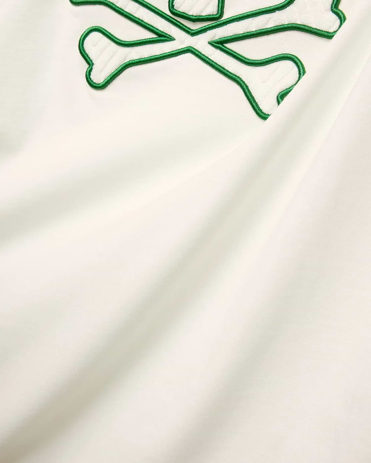 Mens Craig Graphic Tee in cream soft jersey knit, featuring a large embroidered green outline bunny skull crossbones with white terry texture. (5)