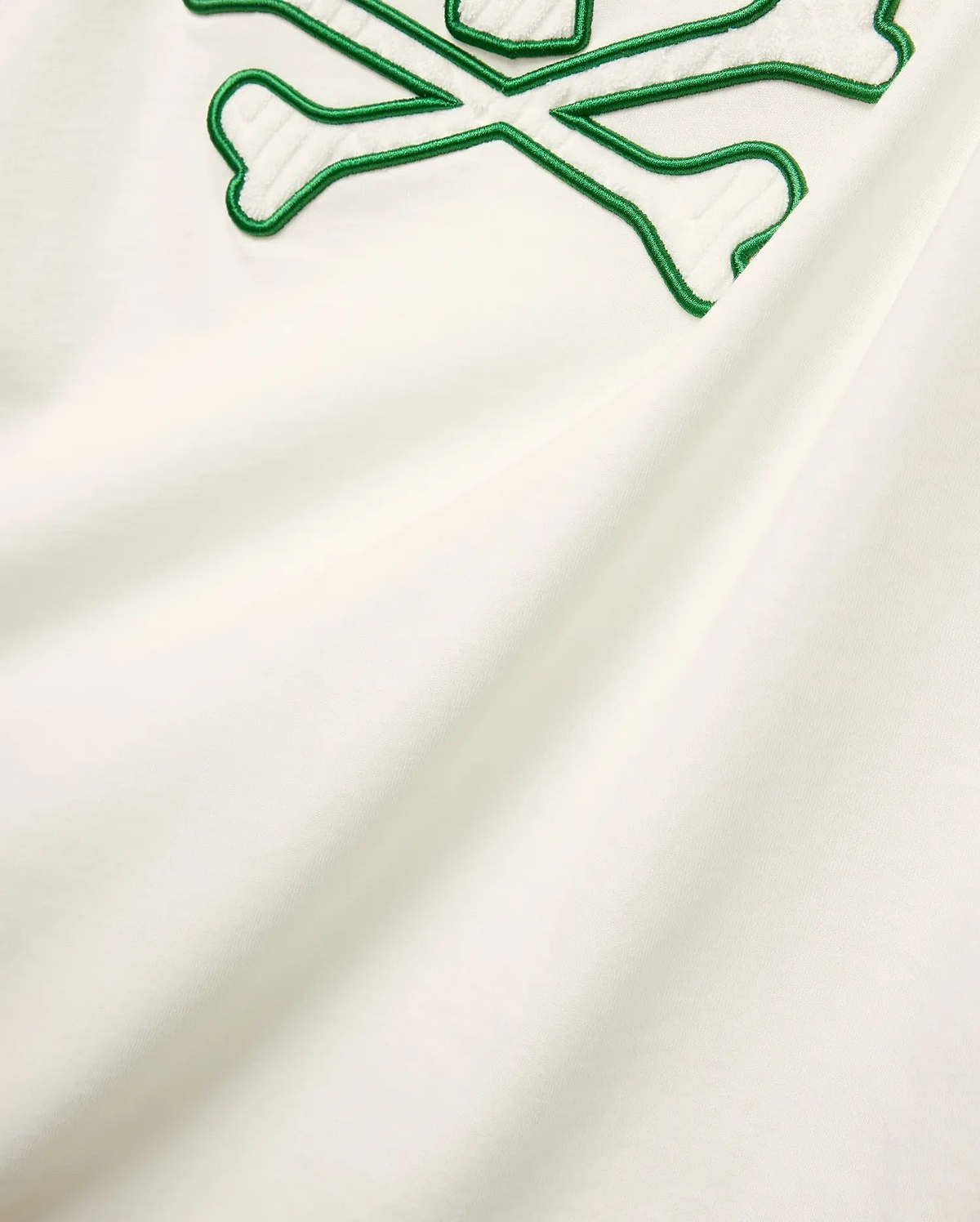 Mens Craig Graphic Tee in cream soft jersey knit, featuring a large embroidered green outline bunny skull crossbones with white terry texture. (5)