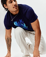 Mens Tanner Graphic Tee, a classic fit navy blue jersey t-shirt with a large chest graphic of multiple bunny skulls in teal, light blue, and darker blue. Paired with light beige textured drawstring pants.