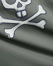 Mens Adler Graphic Tee in dark sage green, soft jersey knit fabric, showcasing a large, distressed white Psycho Bunny skull and crossbones graphic with a bold dark blue outline.