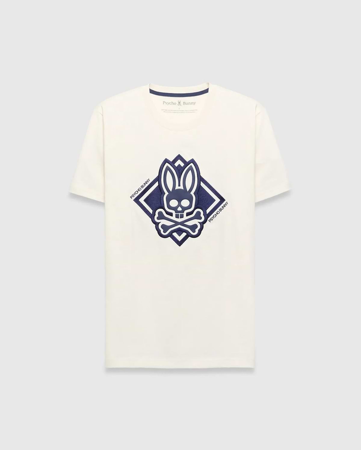 Mens Tobias Graphic Tee, a cream classic fit jersey t-shirt with a large central navy blue Psycho Bunny skull and crossbones logo inside a diamond graphic, featuring Psycho Bunny text.