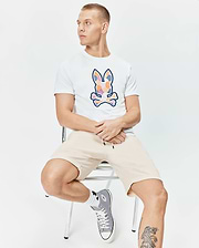 Mens Ethan Graphic Tee, white classic fit jersey with a large colorful mosaic Psycho Bunny skull logo on the chest, paired with relaxed fit beige knit drawstring shorts. (4)